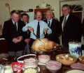 Harbourmasters and lifeboat coxswain Peter Bisson make sure that photographer Brian Green carves the turkey for Georgina Keene's christmas party - 1991